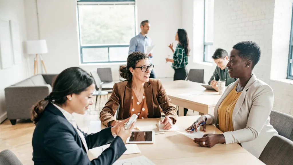 Business meeting with diverse professionals and a business coach in modern office for accountability and strategic planning